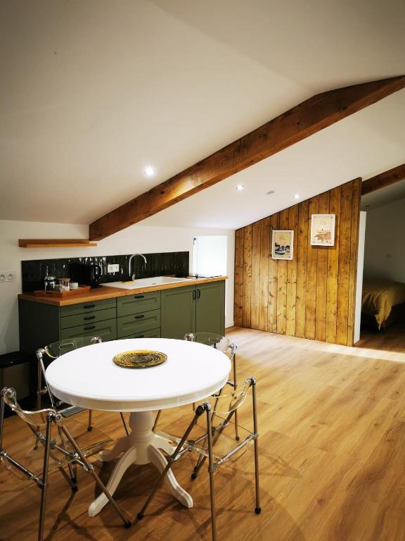 a kitchen with a white table and chairs in a room at Gîte Calme - Vue sur Garonne - Parking privé in Baurech