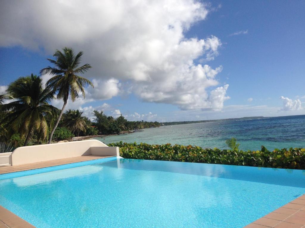 a swimming pool with a view of the ocean at Eden Blue in Sainte-Anne