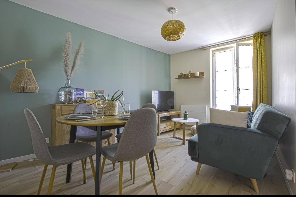 a living room with a dining room table and chairs at Le Cocon de Nuit Normande in Étretat