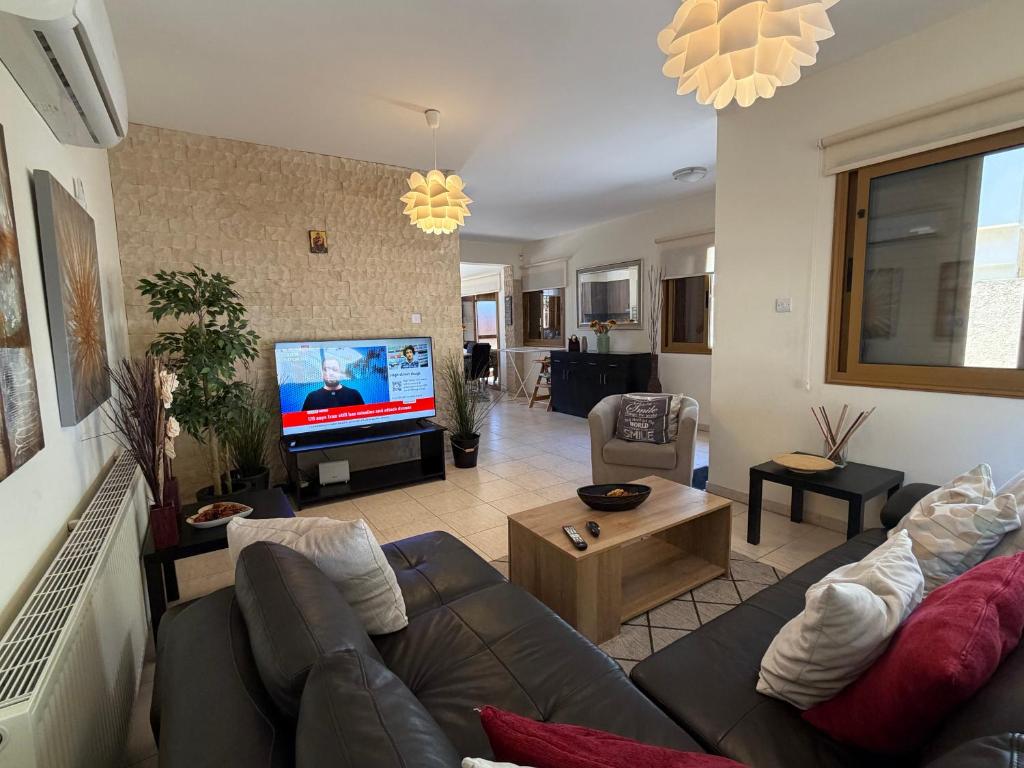 a living room with a couch and a flat screen tv at Alkinoou Residence in Limassol