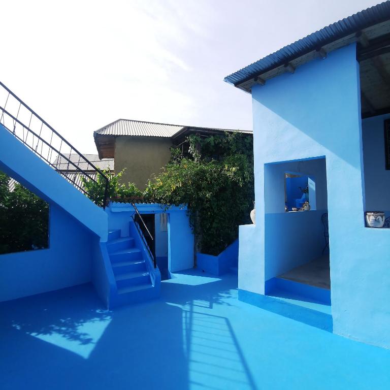 a blue and white house with stairs and a swimming pool at Dar Lala Zhour in Aïn Bouchrik