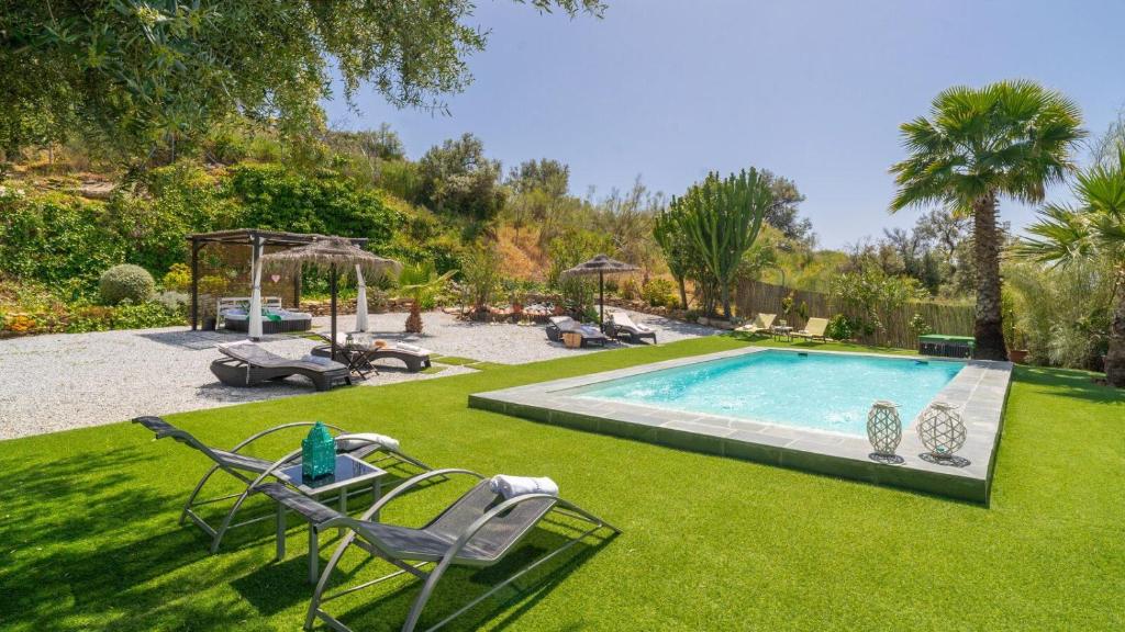 a yard with a swimming pool with chairs at Casa Corazón 44 Torrox by Ruralidays in Torrox