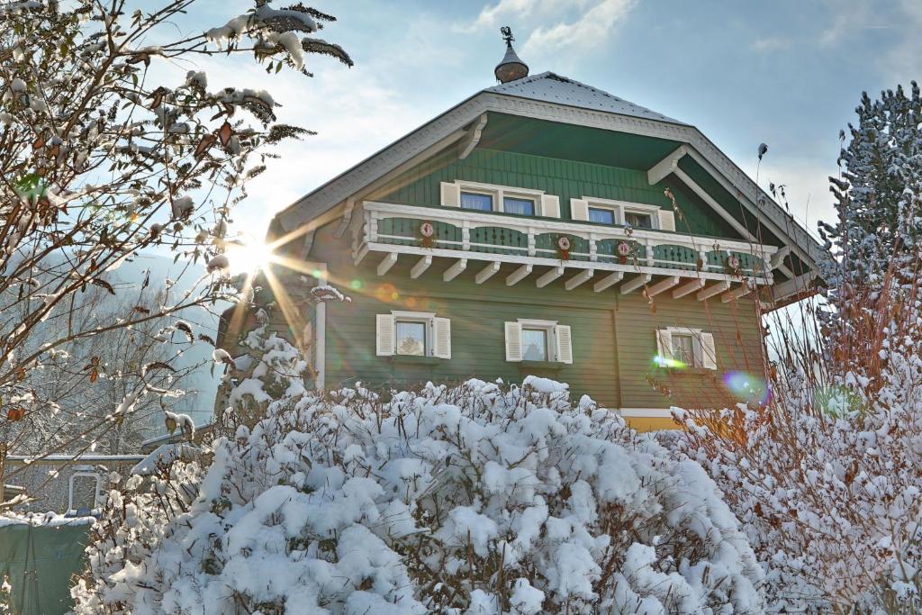 una grande casa con neve per terra di Gästehaus Fuchs a Gröbming