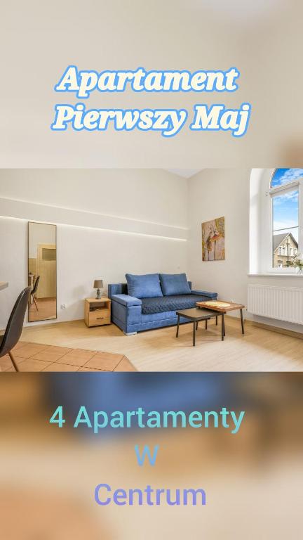 a living room with a blue couch and a table at Apartament Pierwszy Maj in Kudowa-Zdrój