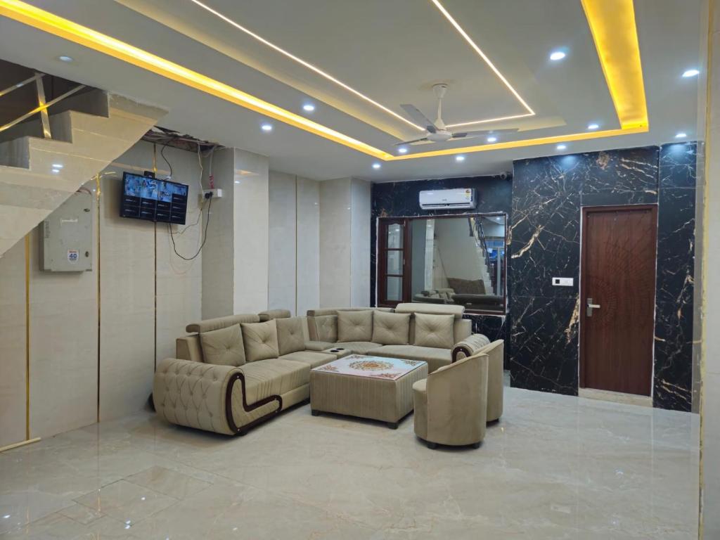 a living room with a couch and a table and a television at Royal Guest House in Jammu