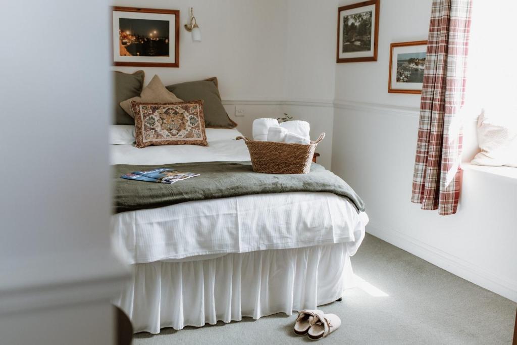 a bedroom with a bed with a basket on it at The Lugger Inn in Weymouth
