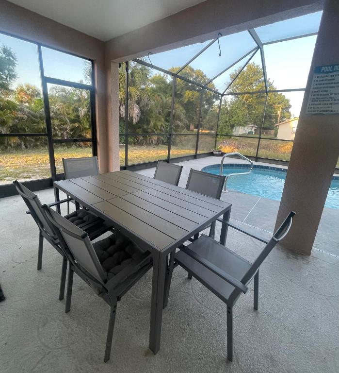 a wooden table with chairs and a swimming pool at Pool Home in Englewood