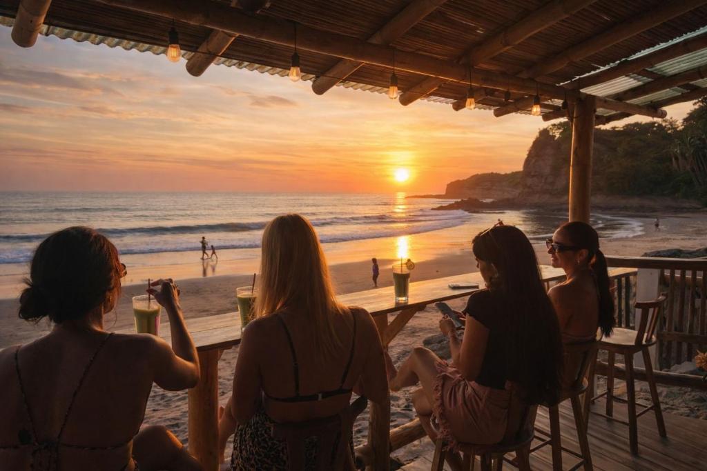 a group of women sitting at a table on the beach at Hostal Rosa Mística in Montañita