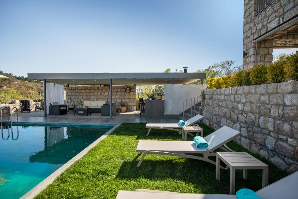 a backyard with a swimming pool and a house at Trioda Kazdağları in Ayvacık