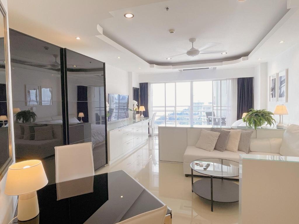 a white living room with a couch and a table at Beautiful Sea View Cozy Condo in Pattaya South