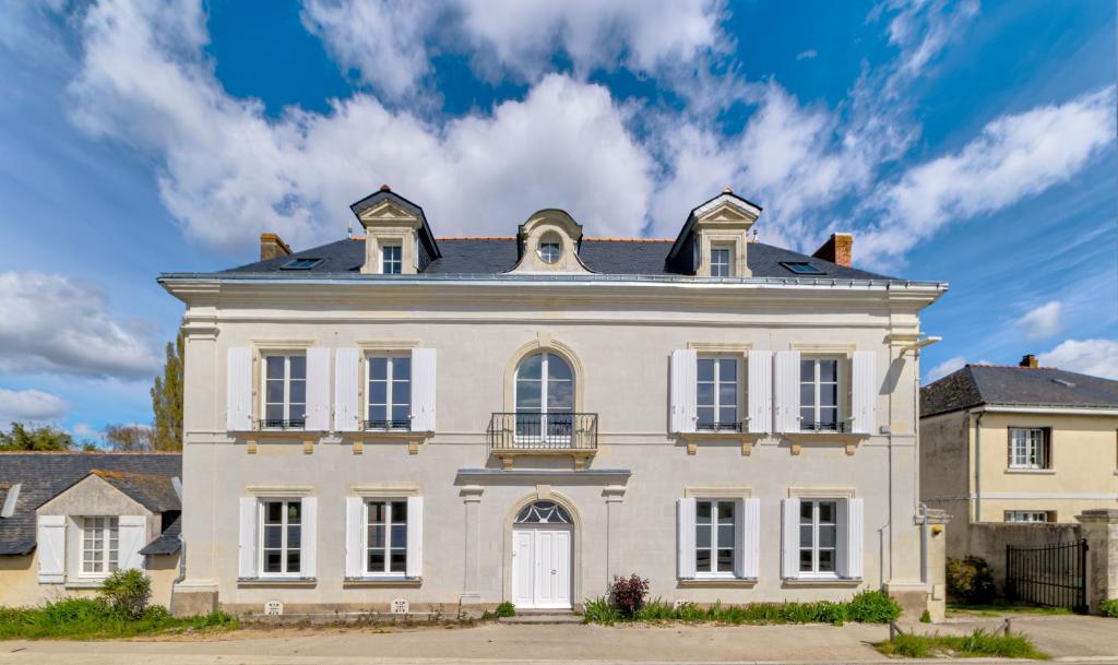 a large white house with a black roof at La ROCHE D'ANJOU in Saint-Mathurin