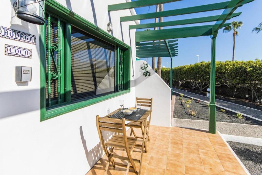 a table and chairs on a patio with a window at Casa Bodega Coco in Puerto del Carmen