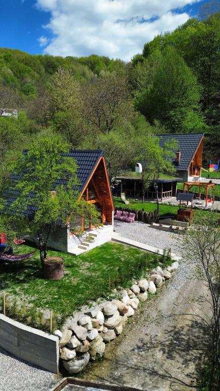 a log cabin with a stone path in front of a house at Cabana AFrame Olanesti in Băile Olăneşti