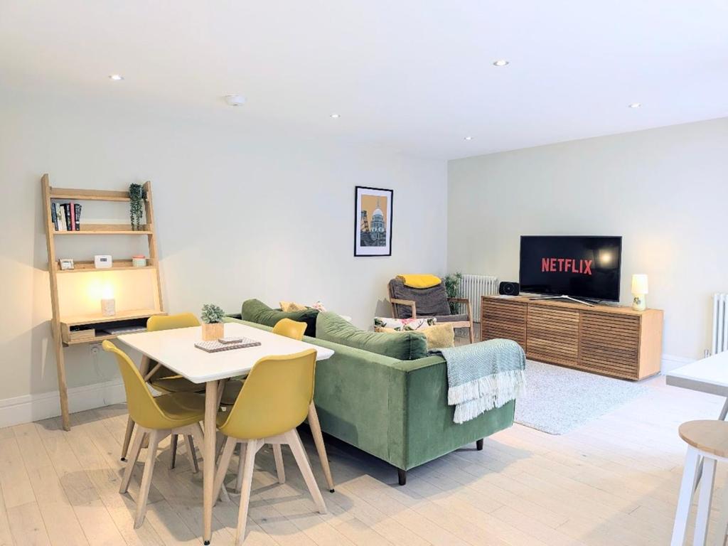 a living room with a couch and a table and a tv at The Mews with free parking in York