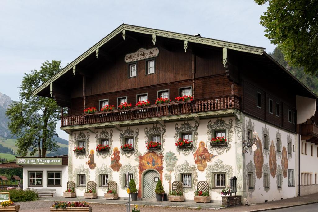 a building with flowers on the front of it at Hotel Walchseer Hof in Walchsee