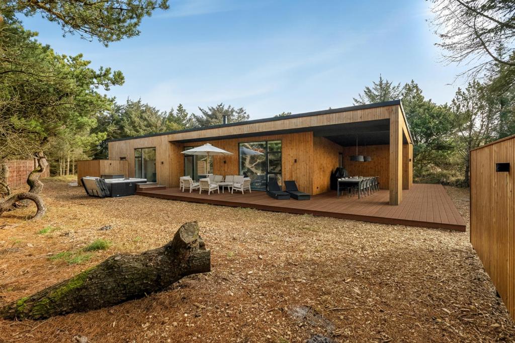 a house in the woods with a large deck at Feriehus 1161 in Ringkøbing