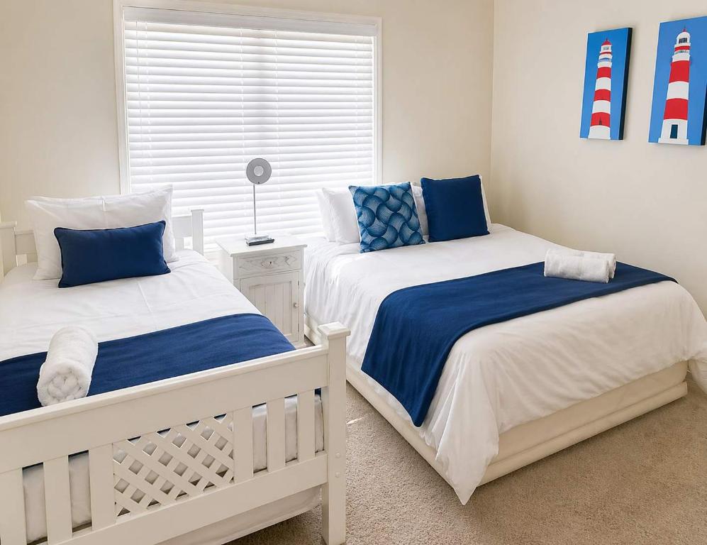 two beds in a bedroom with blue and white at Sunset View 10 @ Langstrand in Langstrand