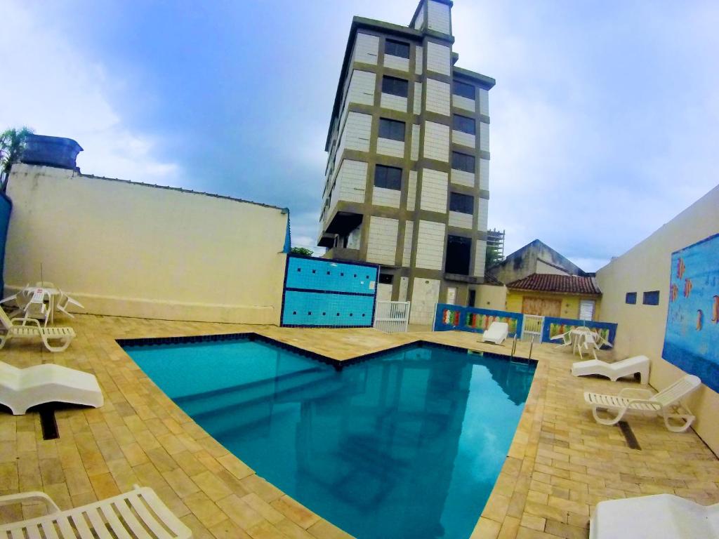 a large swimming pool in front of a building at Hotel Caiçara in Praia Grande