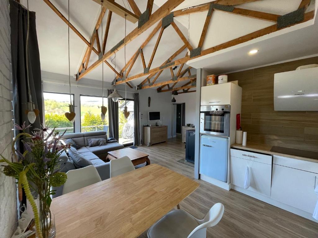 a kitchen and living room with a couch and a table at Ferienhaus am Hennesee in Meschede