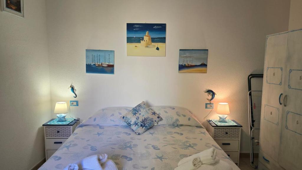 a bedroom with a bed and two night stands with lamps at Casa Stelle Marine in Palau