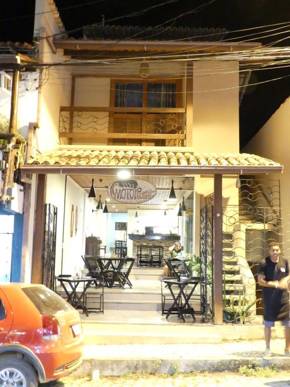 a man standing in front of a restaurant with tables at Flats No Sushi in Itacaré