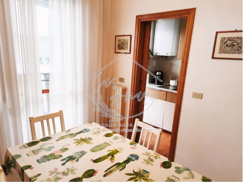 a dining room with a table and a kitchen at CasAmare in Francavilla al Mare