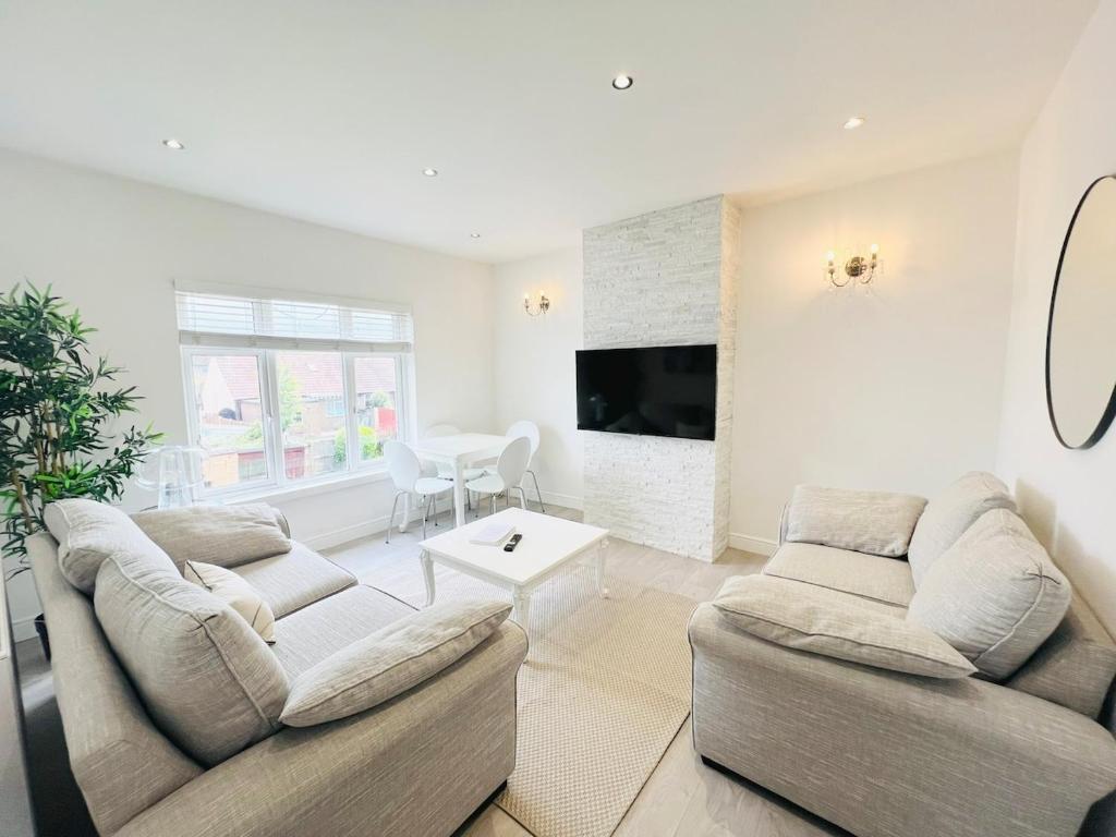 a living room with two couches and a tv at Bright 2-Bed Flat - 1 min to Enfield Lock Station in Enfield Lock