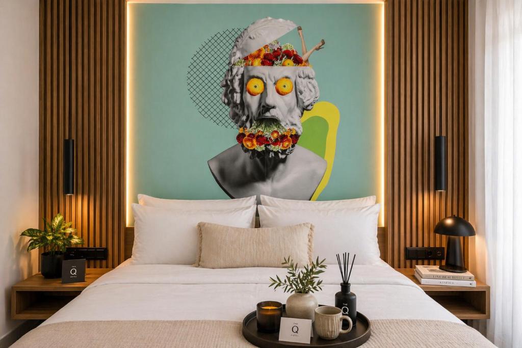 a bedroom with a bed with a painting of a woman at The Q Hotel in Athens