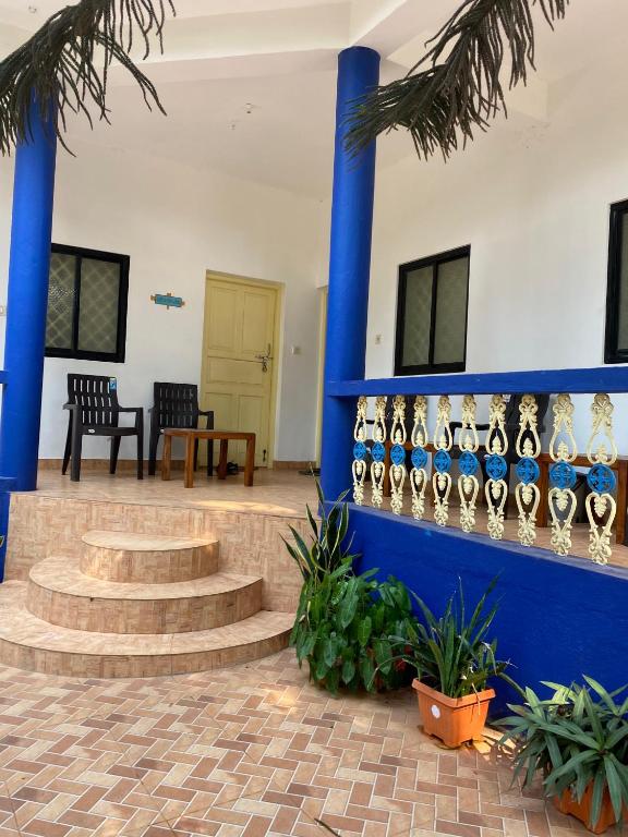 a room with a blue wall and stairs and chairs at Anthony Stays Anjuna in Anjuna