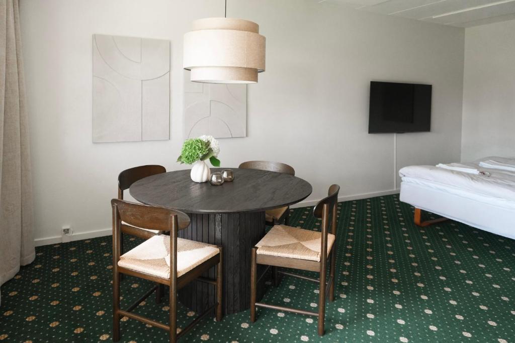 a room with a table and chairs and a bed at Faxe Ladeplads Motel in Hylleholt