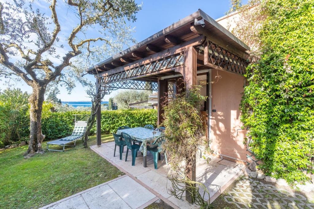 a patio with a table and chairs in a yard at TINA HOME LAKE VIEW in Garda