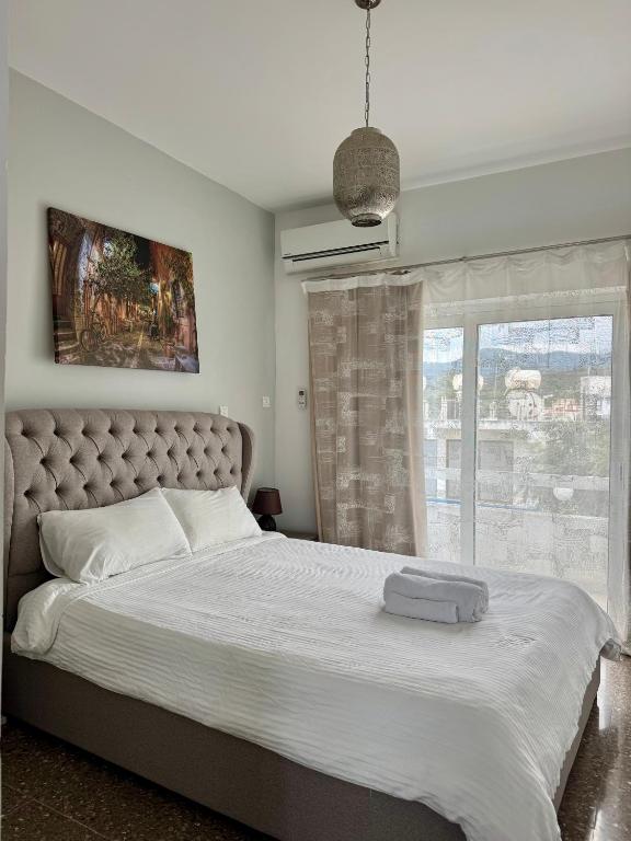 a bedroom with a large bed with a window at GA apartments in Kato Pyrgos