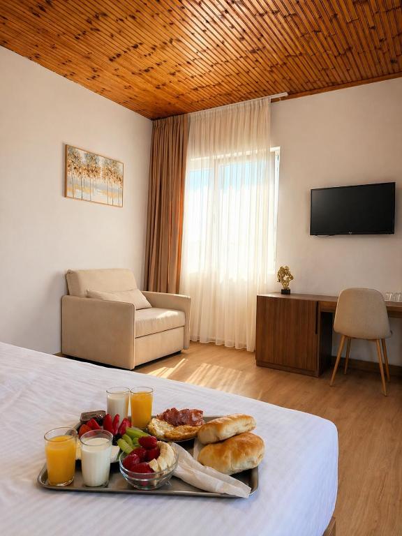 a tray of food on a bed in a room at Hotel Aleks in Shkodër