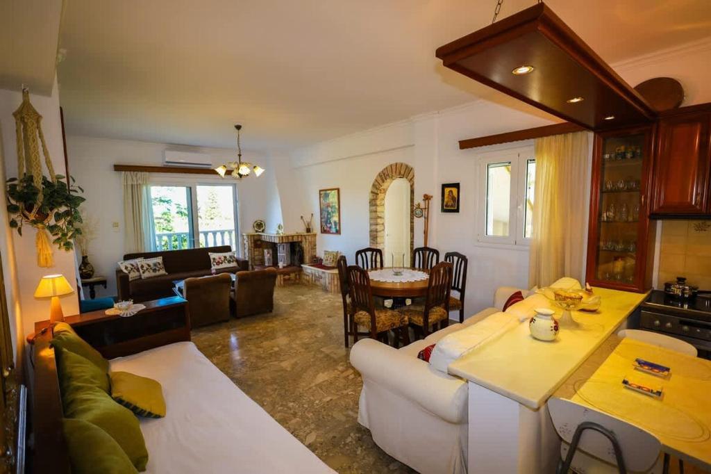 a living room with a white couch and a table at Charming Country House Just Steps from Everything in Kyparissia