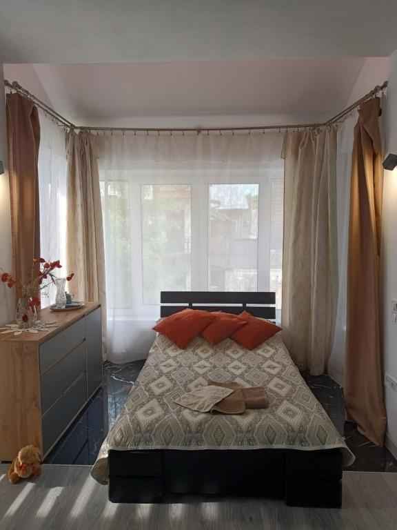 a bedroom with a bed with red pillows and a window at Family Apartments Lviv Villa OLGA in Lviv