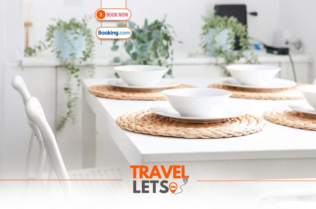 a table with white bowls and plates on it at 2 Bedroom House By Travel Lets Holiday Homes Belfast In City Centre With Free Parking in Belfast