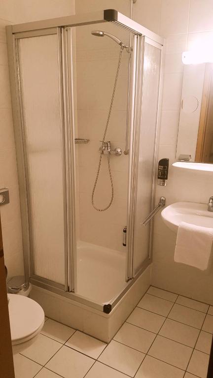 a bathroom with a shower and a toilet and a sink at Hotel Restaurant Krone in Bad Brückenau