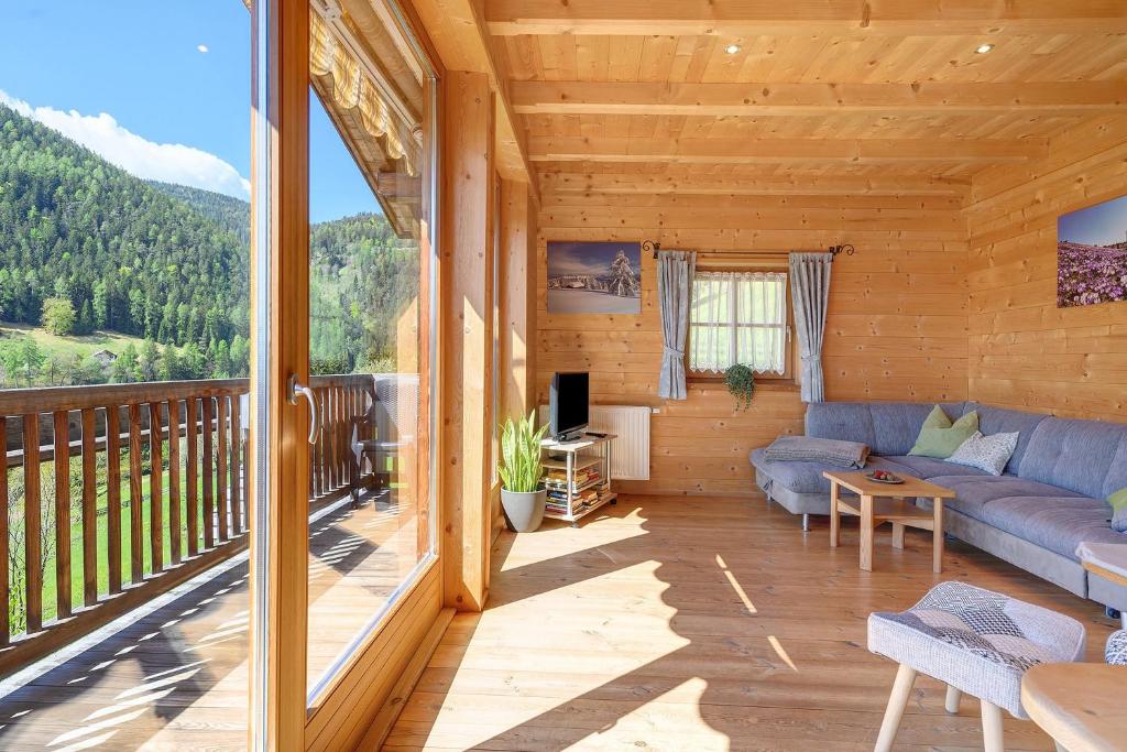 a living room with a couch and a balcony at Ferienhaus Schwarzenbach in San Genesio Atesino