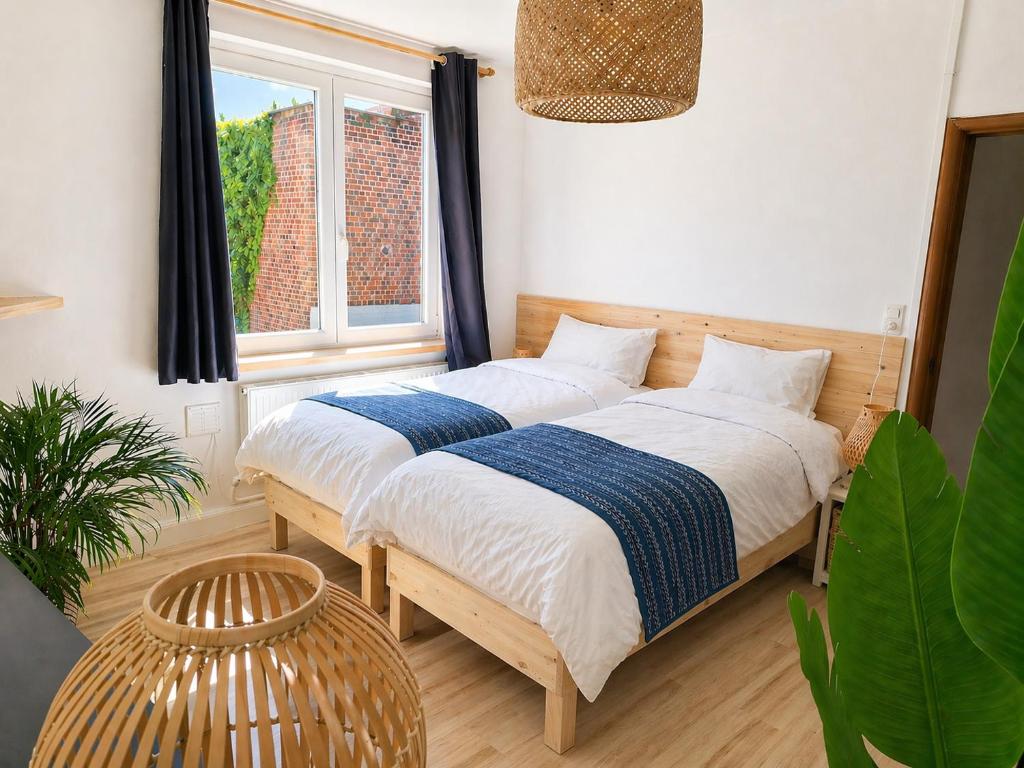 a bedroom with two beds and a window at Appartements Entiers - Centre de Tournai in Tournai