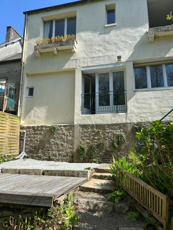a house with a porch and a wooden deck at repos en forêt in Huelgoat