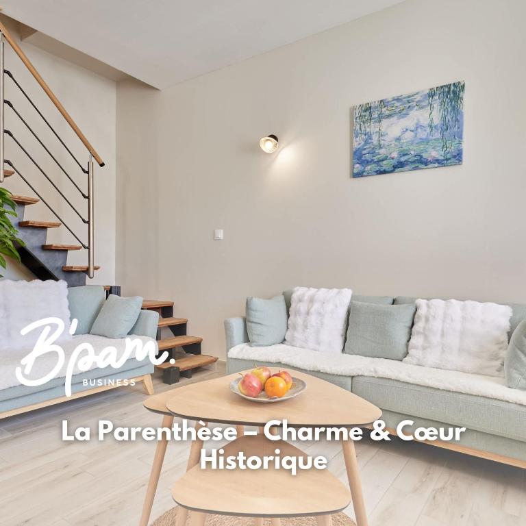 a living room with a couch and a table at La Parenthese - Charme & Coeur Historique in Bayeux