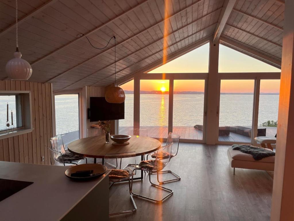 a living room with a table and a view of the ocean at Udsigten over Hjarbæk in Løgstrup