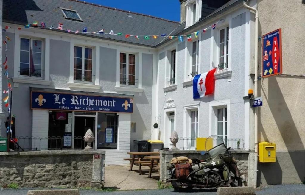 a building with a motorcycle parked in front of it at Gite pour 6 ou chambre pour 2 à FORMIGNY in Formigny