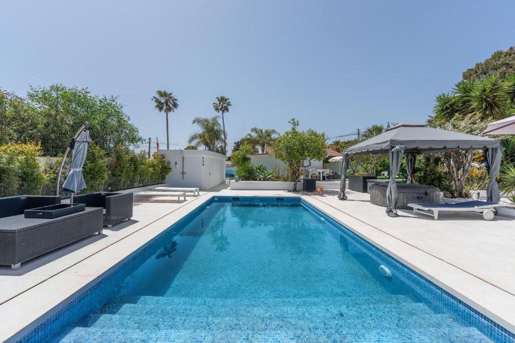 a swimming pool with a gazebo next to a house at Casa Caro in Estepona
