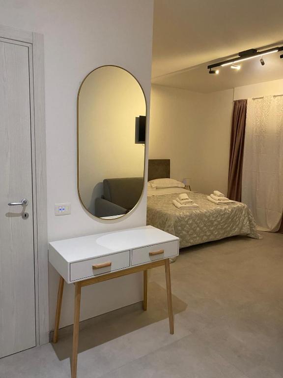 a bedroom with a bed and a mirror on the wall at Kennedy rooms in Isernia