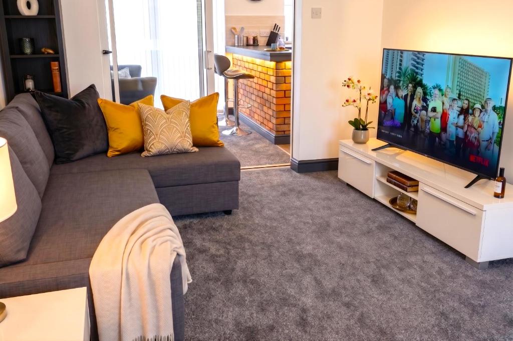 a living room with a couch and a flat screen tv at Green Haven Villa - 4BR Spacious House with Hot tub, Ample Parking, Air Condition, WIFI, Netflix, Patio & Garden in Oxford
