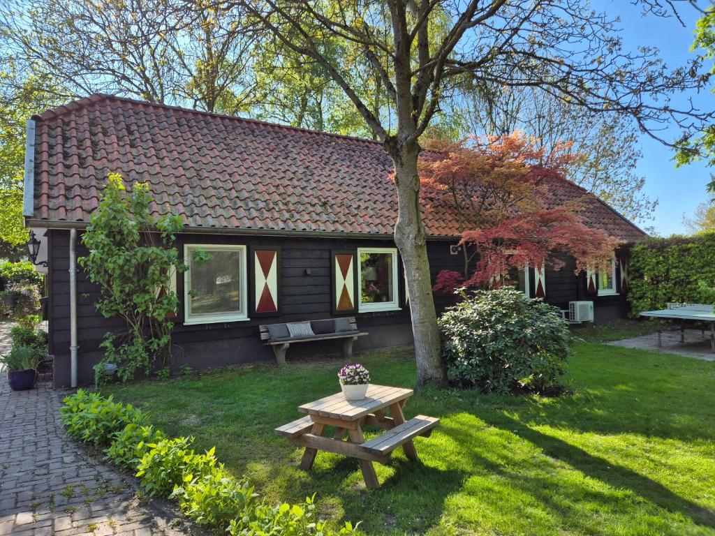 a small house with a picnic table in the yard at Gastenverblijf de Bloesem privé appartement in Lunteren