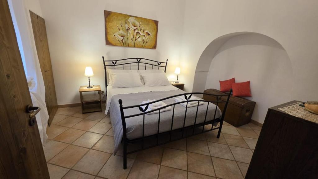 a bedroom with a bed and two tables with lamps at Il Trulletto in Impalata