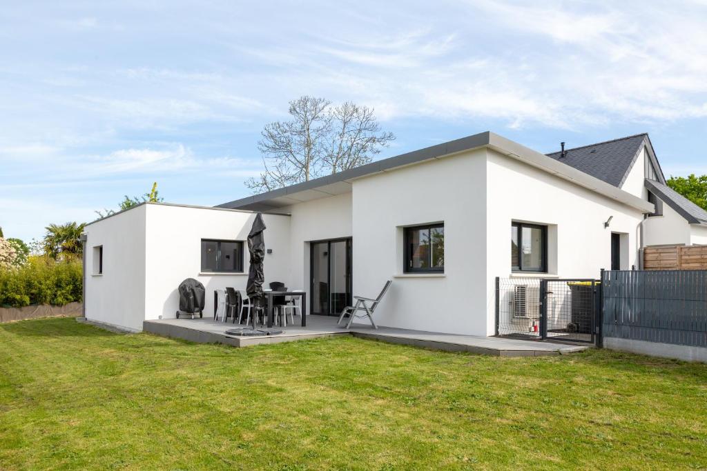 a white house with a lawn in front of it at Maison neuve pmr proche plage in Concarneau