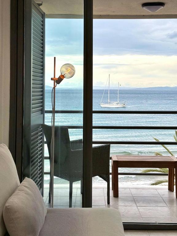 a bedroom with a view of the ocean with a lamp at Apartamentos Stella Maris in Roses